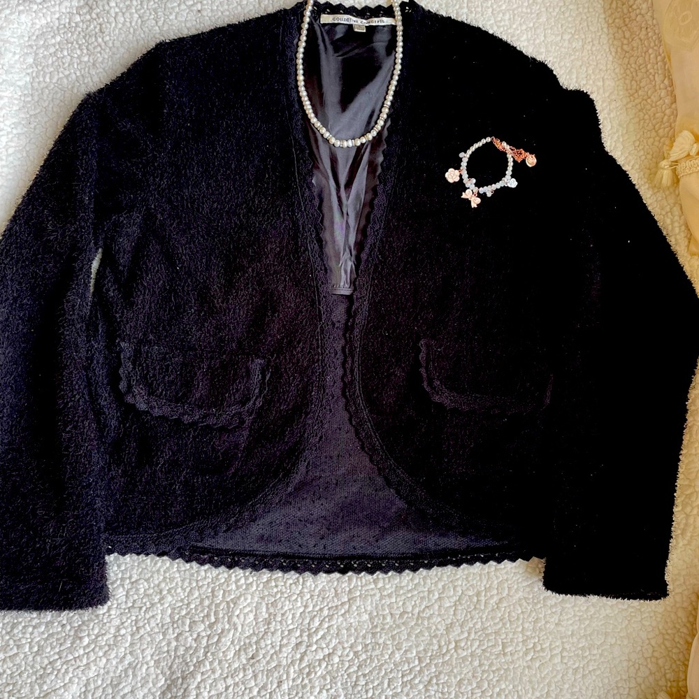 black jacket has a beautiful trim on the pocket and around the jacket.